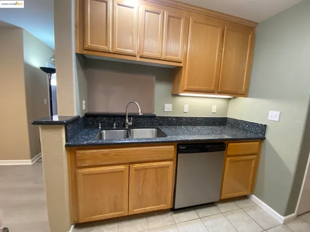 a kitchen with granite countertop cabinets stainless steel appliances and a sink