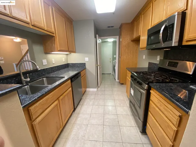 a kitchen with stainless steel appliances granite countertop a stove and a microwave