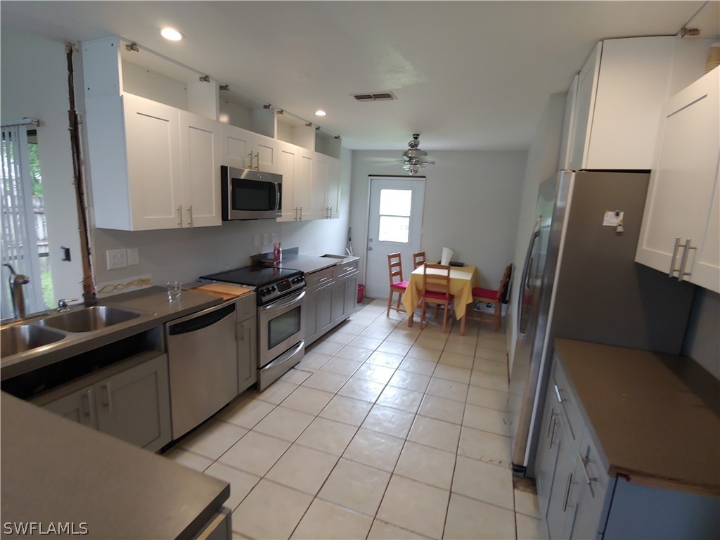 17496 Lebanon Road Fort Myers, FL 33967 - Photo 7 of 21 a kitchen with stainless steel appliances a sink a stove top oven a counter space and cabinets