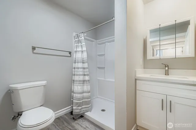 a bathroom with a granite countertop sink toilet and shower