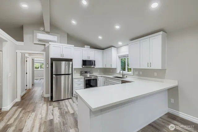 a kitchen with a sink a refrigerator and white cabinets