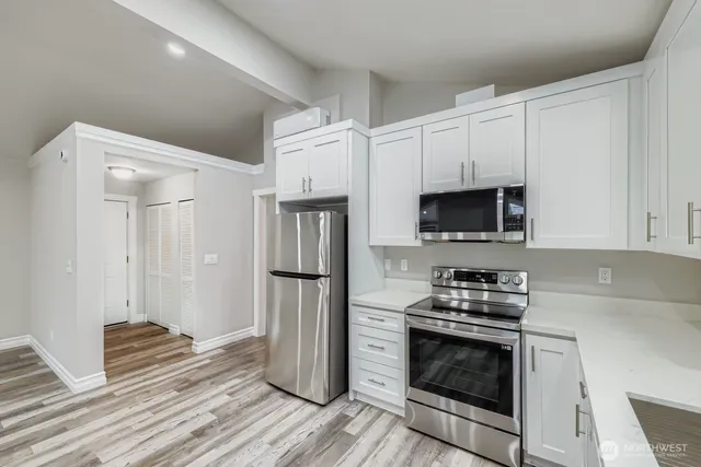 a kitchen with stainless steel appliances a stove a microwave and a refrigerator