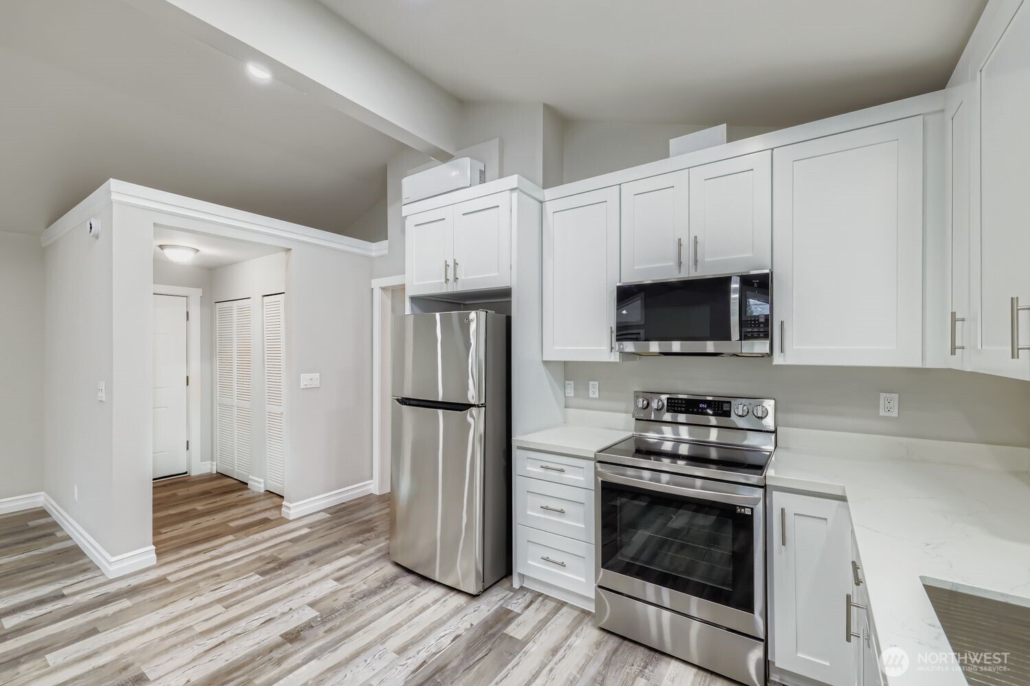 8912 229th Place Southwest, Unit B Edmonds, WA 98026 - Photo 6 of 25 a kitchen with stainless steel appliances a stove a microwave and a refrigerator