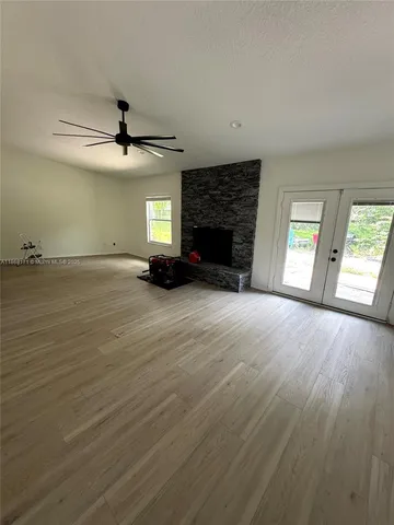 a view of an empty room with a fireplace and a window