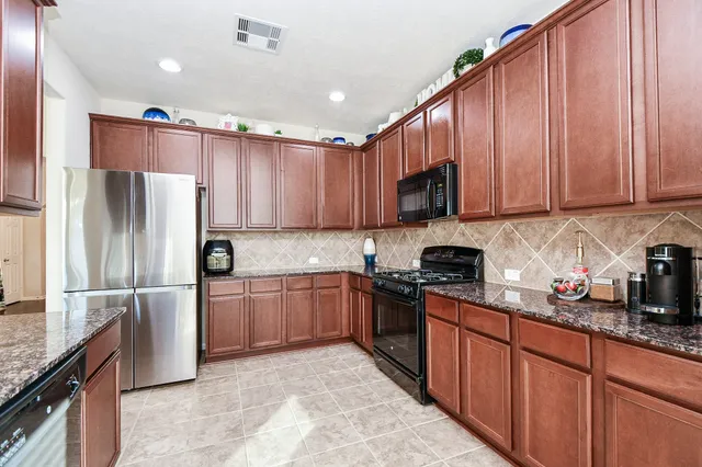 a kitchen with stainless steel appliances granite countertop a stove a sink and a microwave