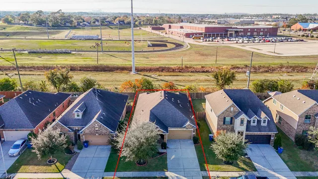 an aerial view of residential houses with outdoor space and ocean view