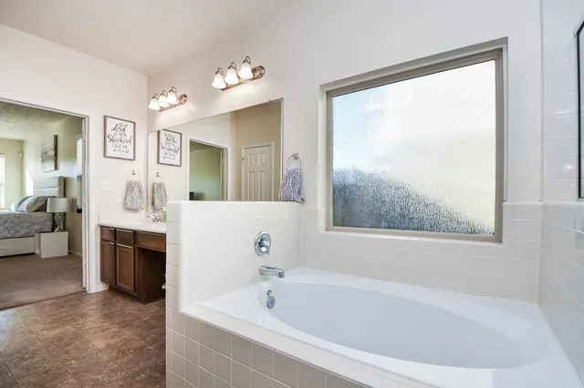 a bathroom with a bathtub and a window