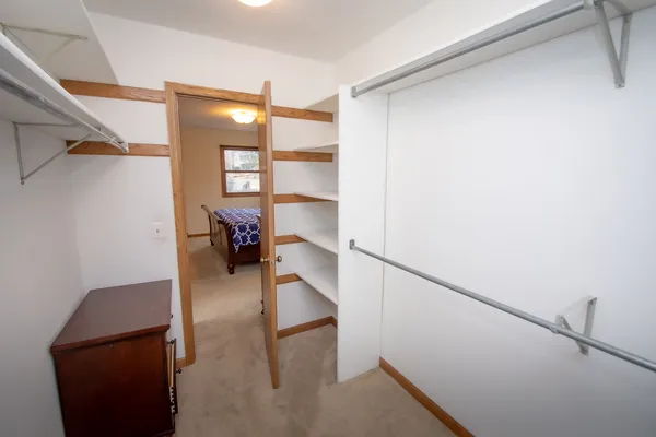 a view of a hallway to a livingroom with furniture and windows