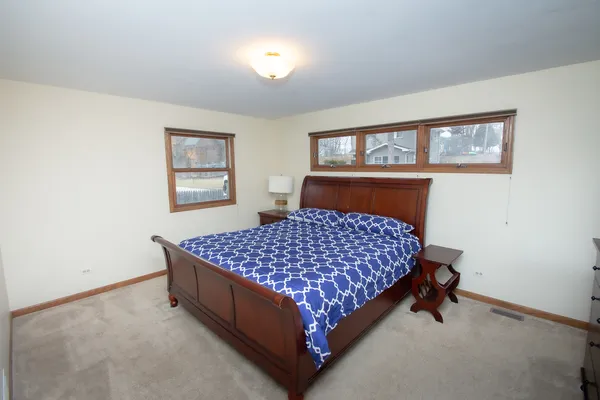 a bed sitting in a bedroom next to a window