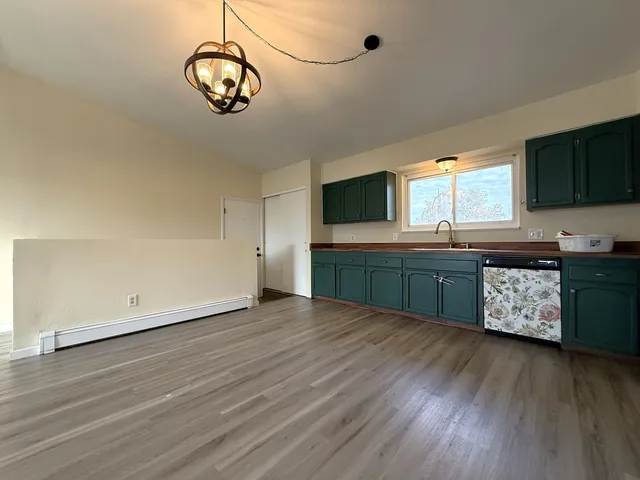 a kitchen with stainless steel appliances granite countertop a sink cabinets and wooden floor