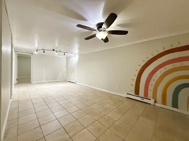 a view of a livingroom with a ceiling fan and entryway