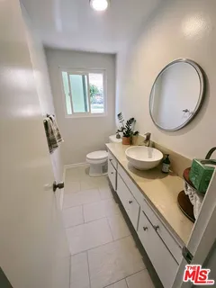 a bathroom with a granite countertop sink and a mirror