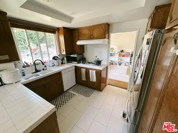 a kitchen with stainless steel appliances a stove a sink and a refrigerator