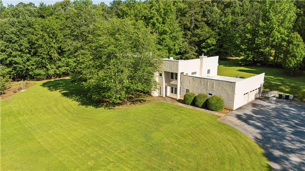 a view of a house with a yard and large trees