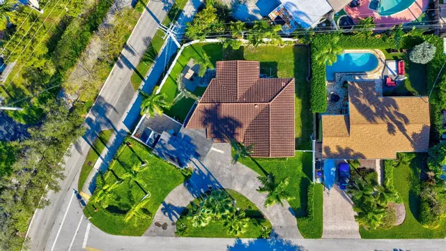 an aerial view of residential house with outdoor space and trees all around