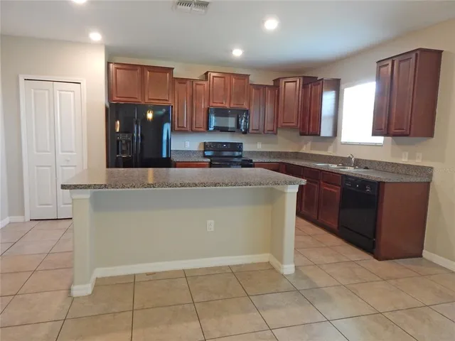 a kitchen with stainless steel appliances granite countertop a stove top oven a sink and a granite counter tops