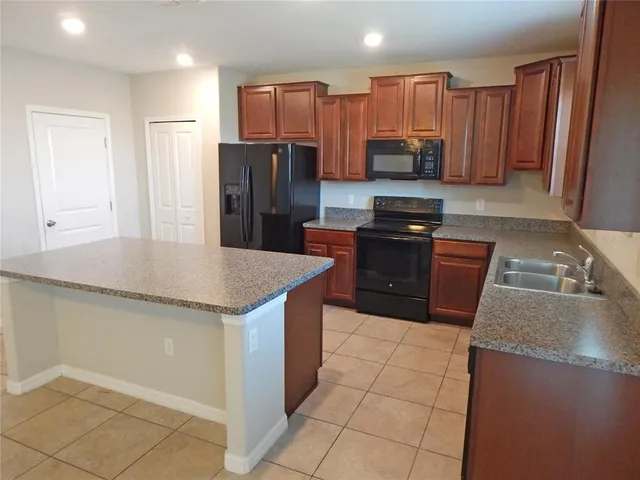a kitchen with stainless steel appliances granite countertop a refrigerator and a stove