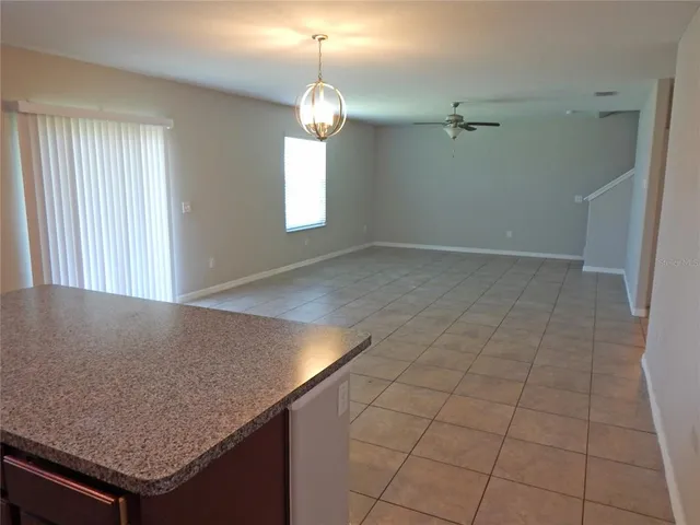 an empty room with kitchen view