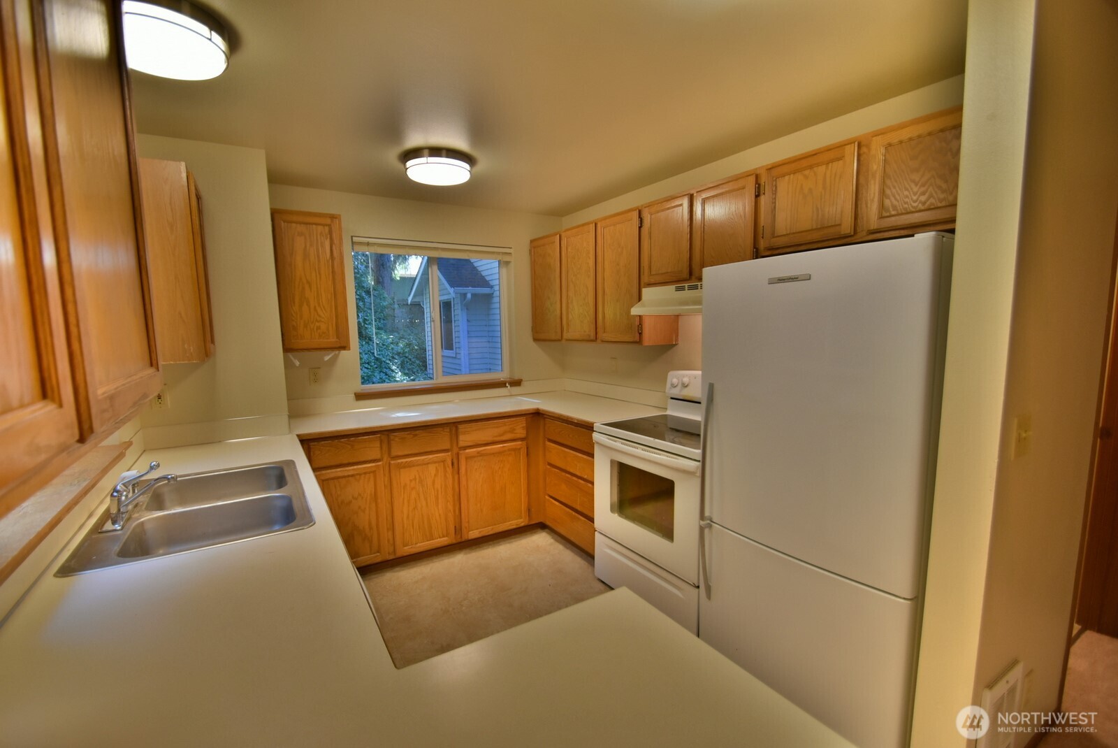 7616 200th Street Southwest, Unit 2 Edmonds, WA 98026 - Photo 4 of 12 a kitchen with granite countertop a refrigerator and a sink