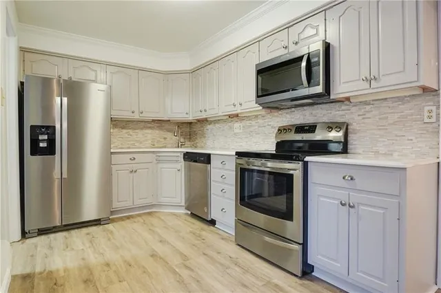 a kitchen with white cabinets stainless steel appliances and sink