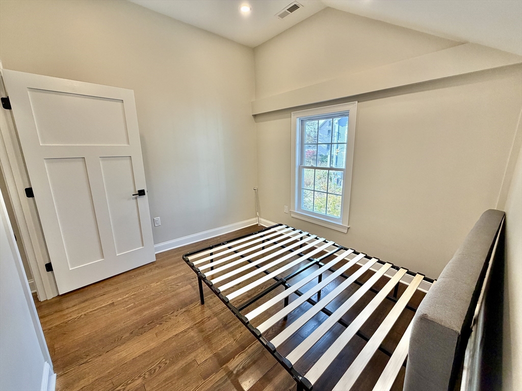 48 Springs Road, Unit RD Bedford, MA 01730 - Photo 17 of 27 a bedroom with a bed and wooden floor