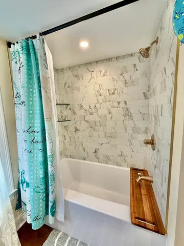 a bathroom with a bathtub and shower