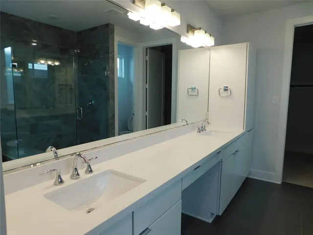 a bathroom with a sink double vanity and a shower