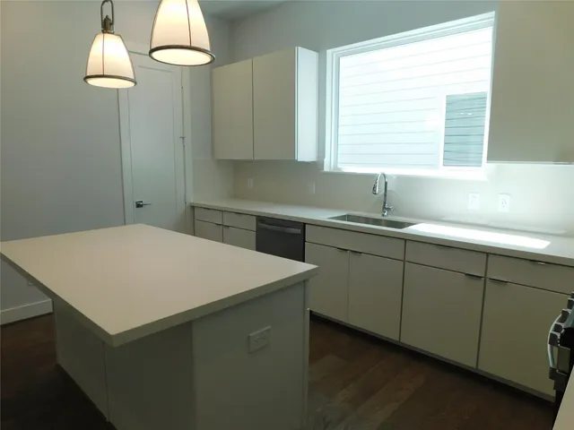 a kitchen with a sink a window and chandelier