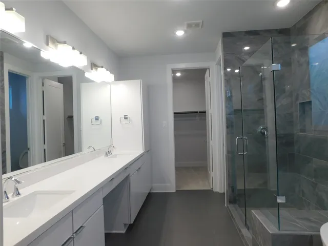 a bathroom with a double vanity sink mirror and shower