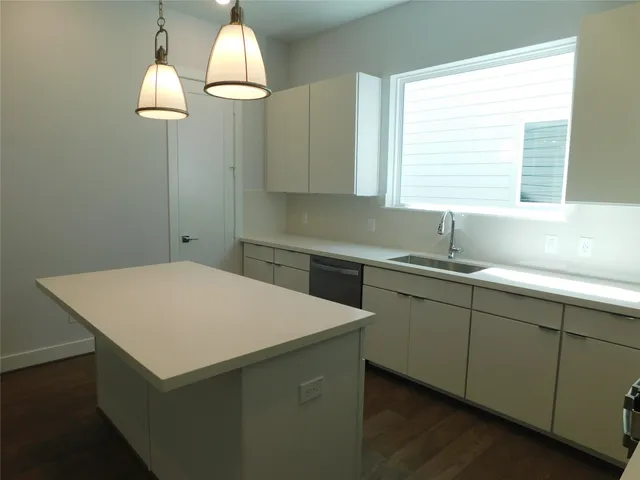 a kitchen with a sink a window and chandelier