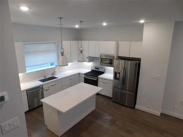 a kitchen with a sink a refrigerator and a stove