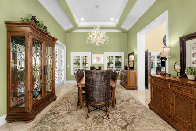 a bedroom with a beds chandelier and a window