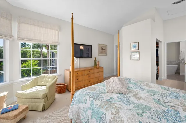 a spacious bedroom with a bed and a flat screen television