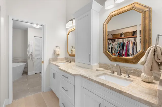 a en suite bathroom with a granite countertop double vanity sink and a mirror