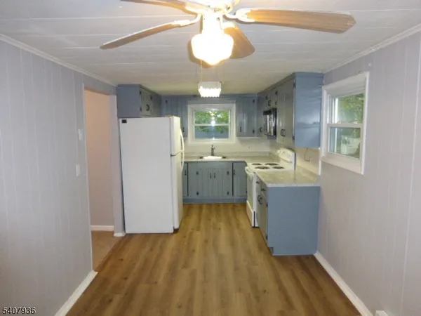 a kitchen with wooden floors and refrigerator