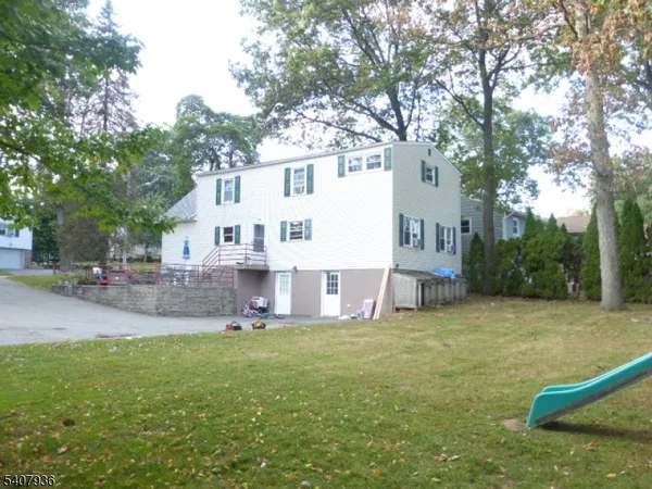 a view of a house with a yard and a tree