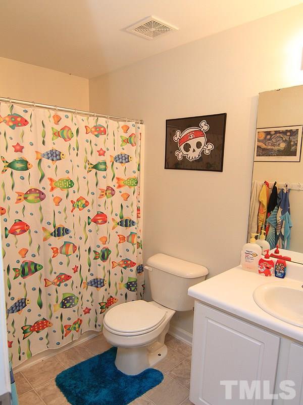 3505 Pinkham Way Raleigh, NC 27616 - Photo 18 of 24 a bathroom with a toilet a sink and a shower curtain