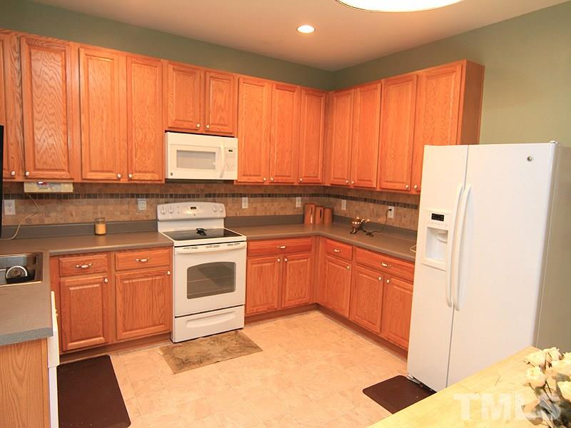 3505 Pinkham Way Raleigh, NC 27616 - Photo 9 of 24 a kitchen with a white stove top oven sink and cabinets