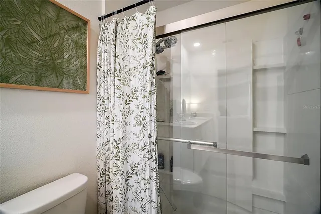 a bathroom with a shower curtain and a toilet