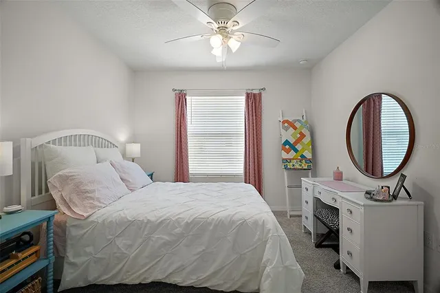 a bedroom with a bed a dresser and potted plants