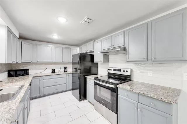 a kitchen with cabinets stainless steel appliances and a counter space