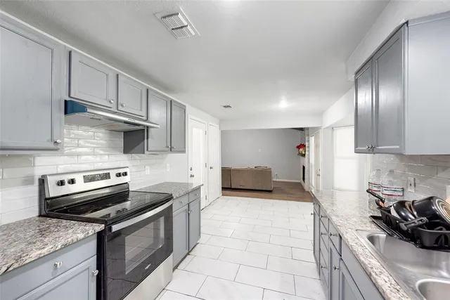 a kitchen with stainless steel appliances granite countertop a sink stove and cabinets