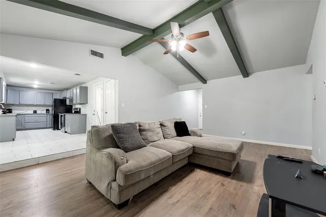 a living room with furniture and a wooden floor