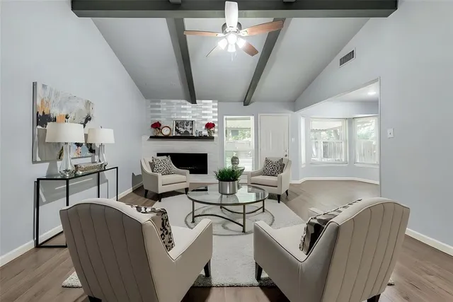 a living room with furniture a fireplace and a flat screen tv