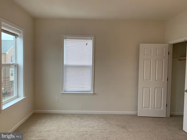 an empty room with windows and closet