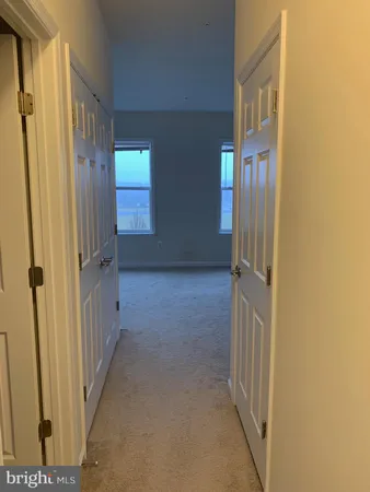 a view of a hallway with wooden floor and windows