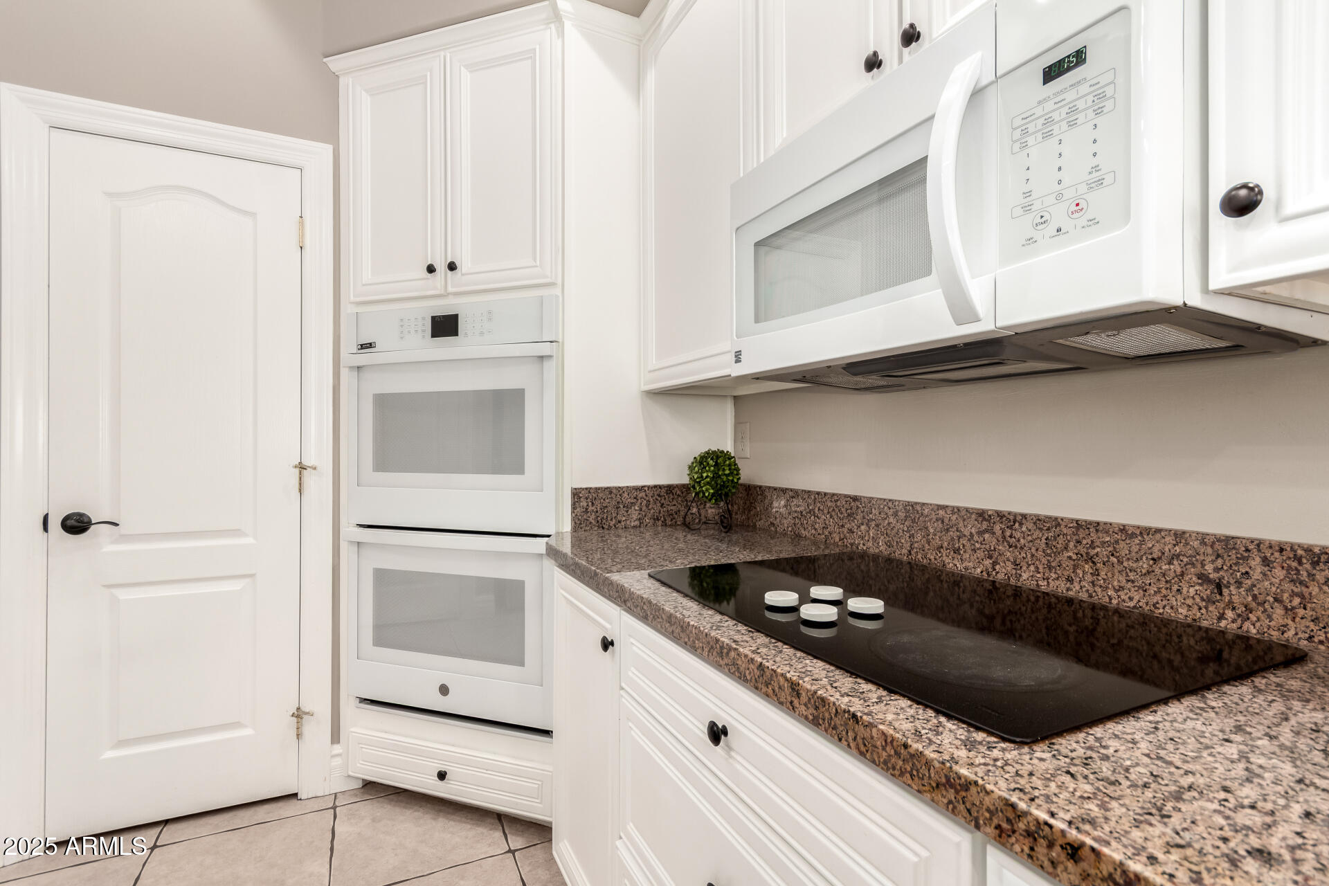 3528 East Decatur Street Mesa, AZ 85213 - Photo 17 of 55 a kitchen with white cabinets and a stove