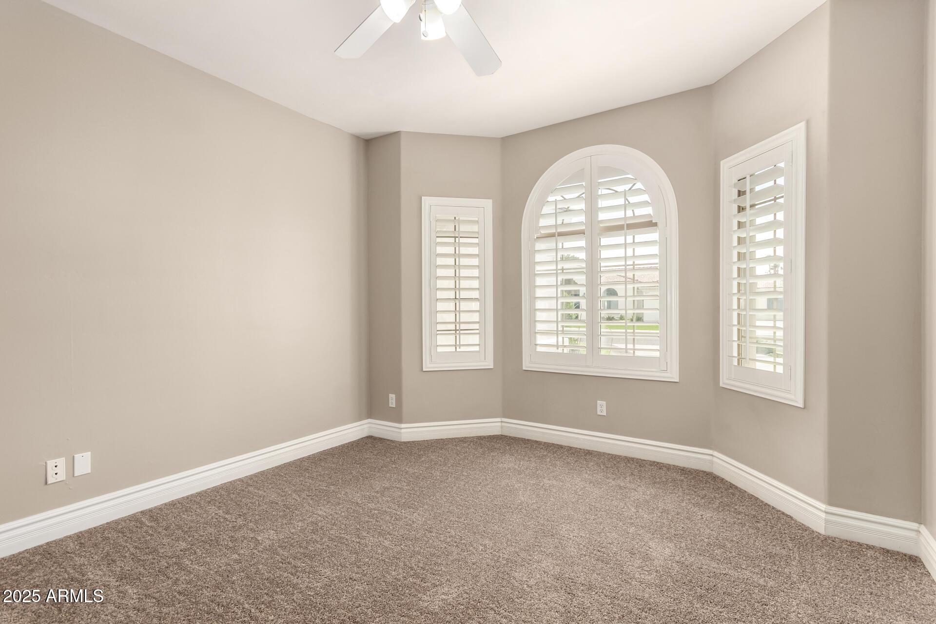 3528 East Decatur Street Mesa, AZ 85213 - Photo 27 of 55 an empty room with windows and chandelier fan