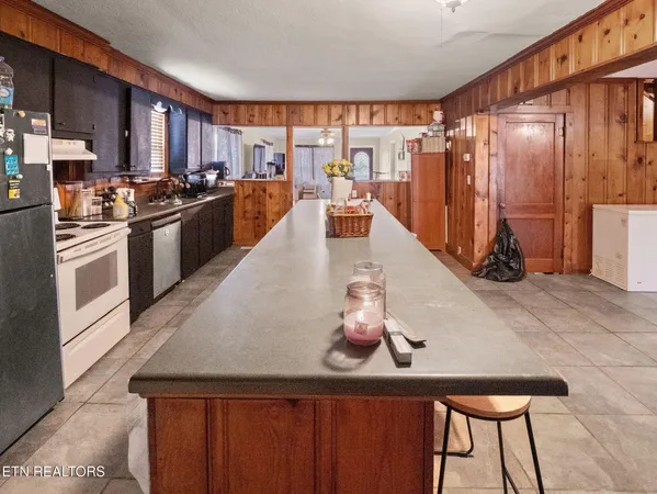 a kitchen with stainless steel appliances granite countertop a sink a stove and a refrigerator