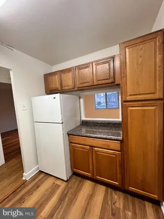a kitchen with a refrigerator a stove top oven and cabinets